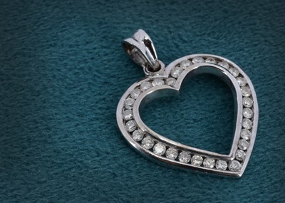 Lot 11 - A 9ct white gold and diamond set open heart pendant