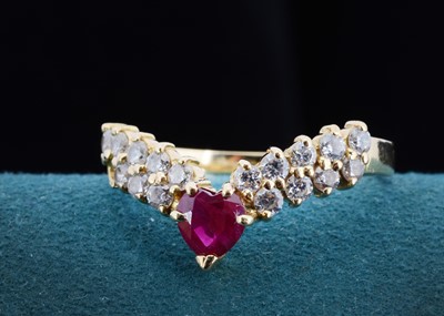 Lot 22 - A continental 750 marked ruby and diamond wishbone ring