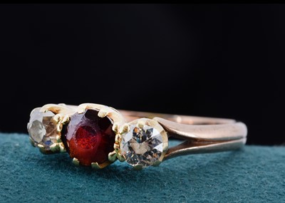 Lot 23 - An 18ct gold garnet and diamond three stone dress ring