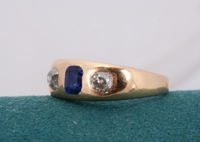 Lot 142 - A three stone diamond and blue paste set dress ring