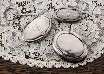 Lot 231 - Three oval silver compacts with ring attachments