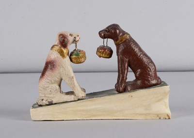 Lot 215 - A late 19th century Thüringen seated dogs holding baskets squeak toy