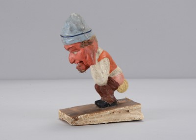 Lot 244 - A mid 19th century Thüringen Dukatenscheißer man ‘shitting’ money squeak toy