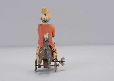 Lot 434 - An early 20th century German composition clockwork clown riding a donkey backwards