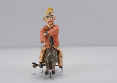 Lot 434 - An early 20th century German composition clockwork clown riding a donkey backwards