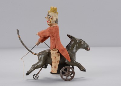 Lot 434 - An early 20th century German composition clockwork clown riding a donkey backwards