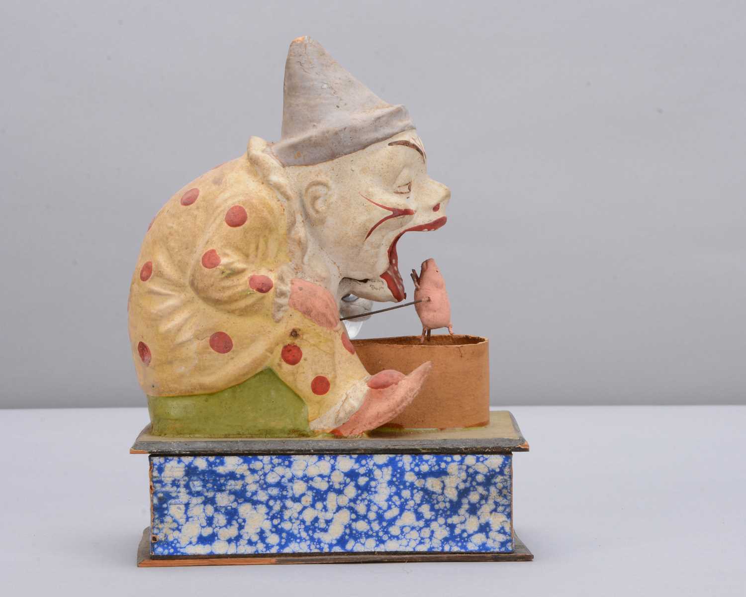 Lot 438 - A late 19th century Thüringen white faced clown eating a pig crank handled ‘eater’