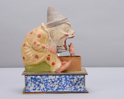 Lot 438 - A late 19th century Thüringen white faced clown eating a pig crank handled ‘eater’