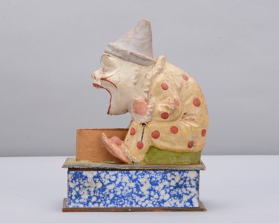 Lot 438 - A late 19th century Thüringen white faced clown eating a pig crank handled ‘eater’
