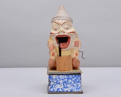 Lot 438 - A late 19th century Thüringen white faced clown eating a pig crank handled ‘eater’