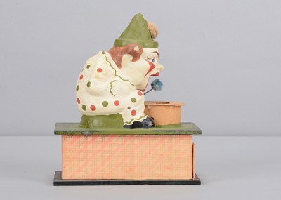 Lot 440 - An early 20th century Thüringen white faced clown eating a pom-pom crank handled ‘eater’