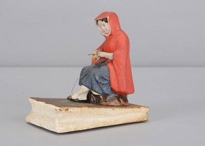 Lot 442 - A mid 19th century Thüringen papier-mâché girl knitting squeak toy