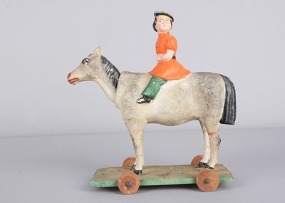 Lot 444 - A mid 19th century Thüringen composition boy on nodding donkey pull along toy