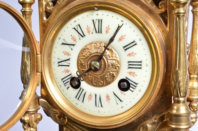Lot 21 - A late 19th or early 20th century brass mantle clock garniture