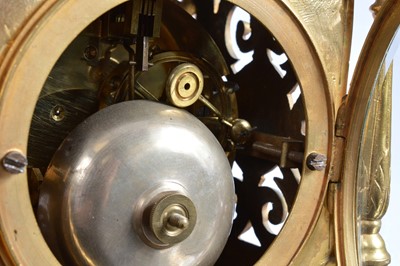 Lot 21 - A late 19th or early 20th century brass mantle clock garniture