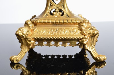 Lot 21 - A late 19th or early 20th century brass mantle clock garniture