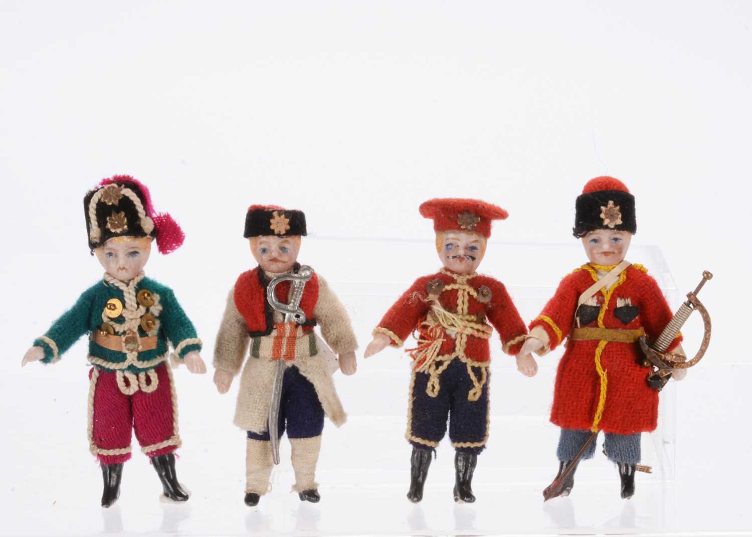 Lot 927 - Four small German all-bisque dolls’ house soldier dolls