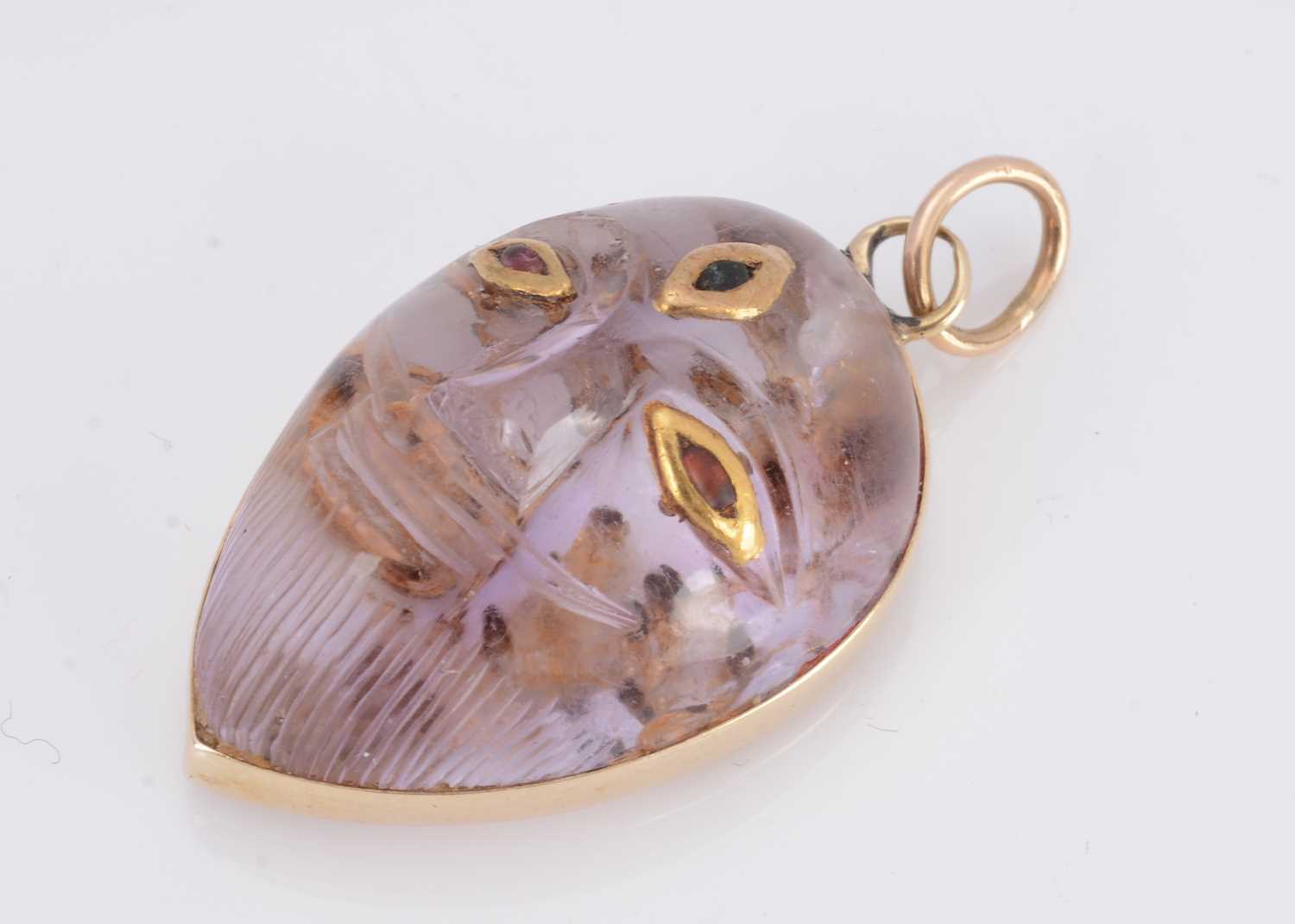 Lot 12 - An Indian amethyst gold and gem set deity pendant