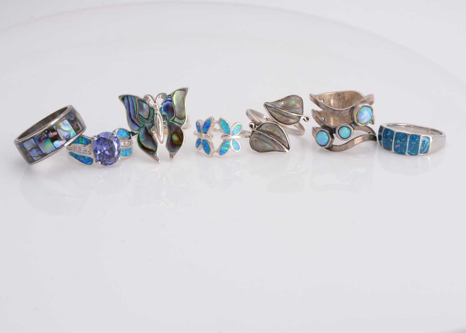 Lot 54 - Seven opal, abalone and gem set dress rings