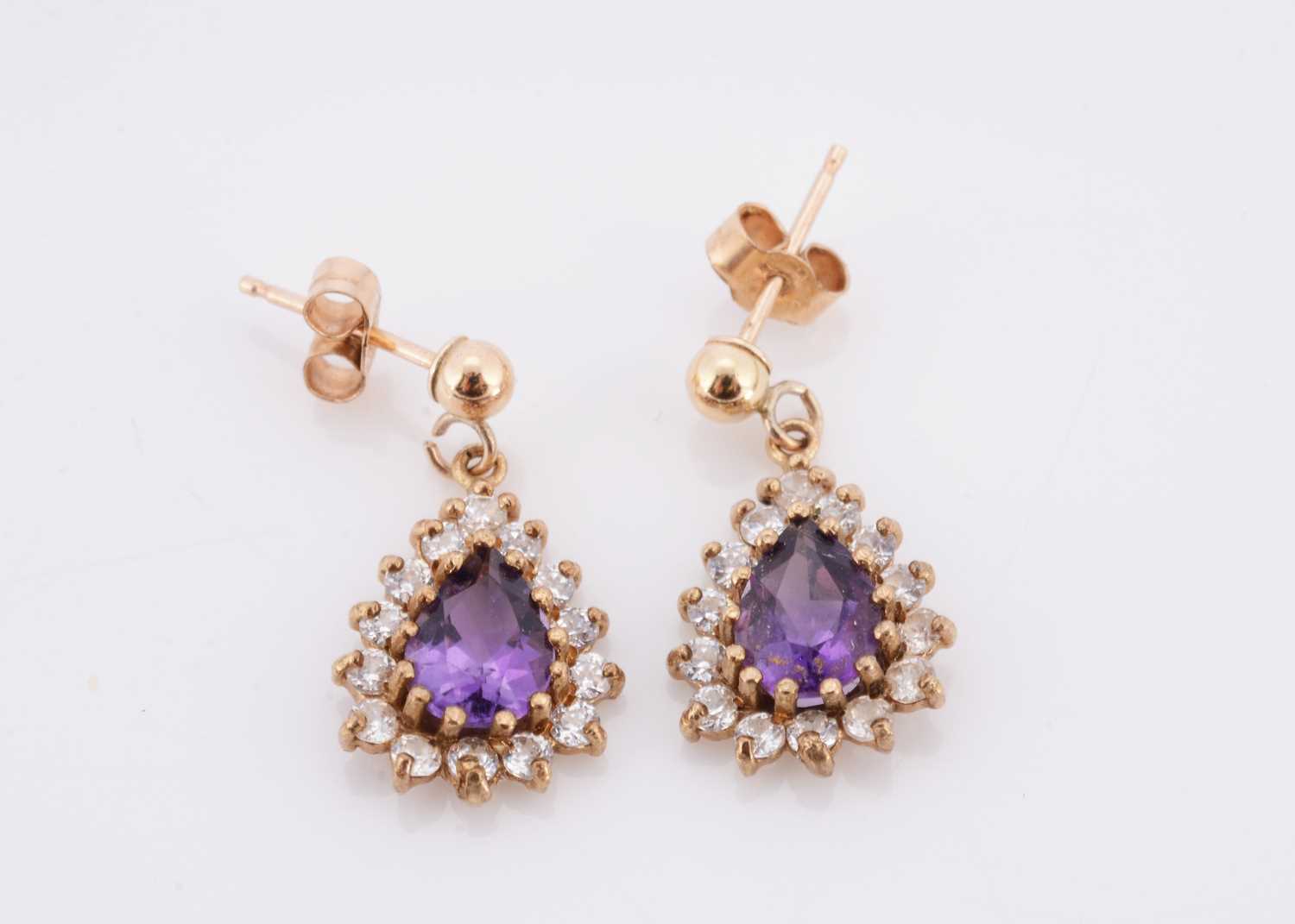 Lot 60 - A pair of amethyst and cubic zirconia drop oval earrings