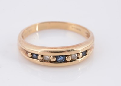 Lot 63 - A channel set sapphire and diamond half hoop 9ct gold dress ring