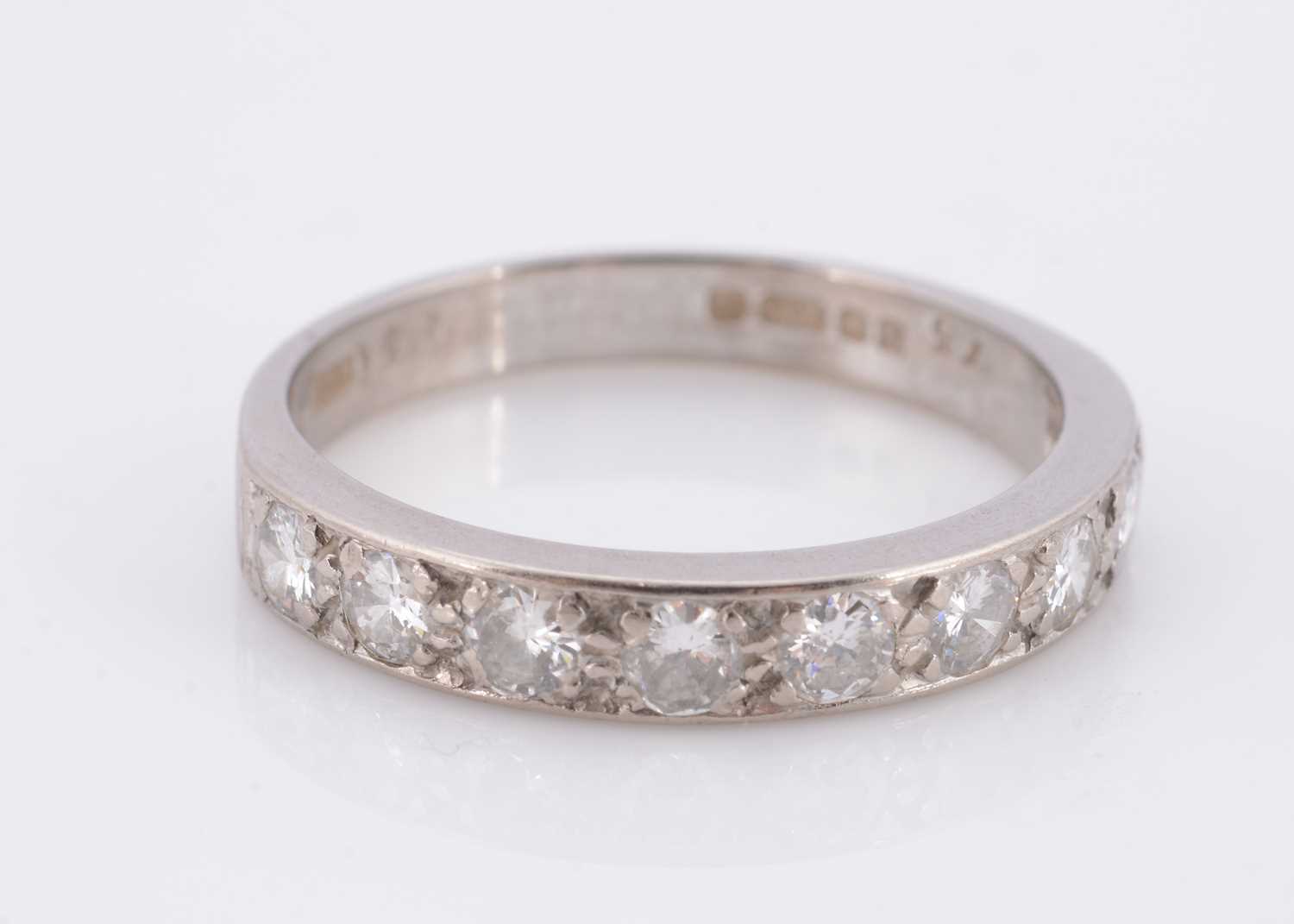 Lot 77 - An 18ct gold nine stone diamond half hoop eternity ring