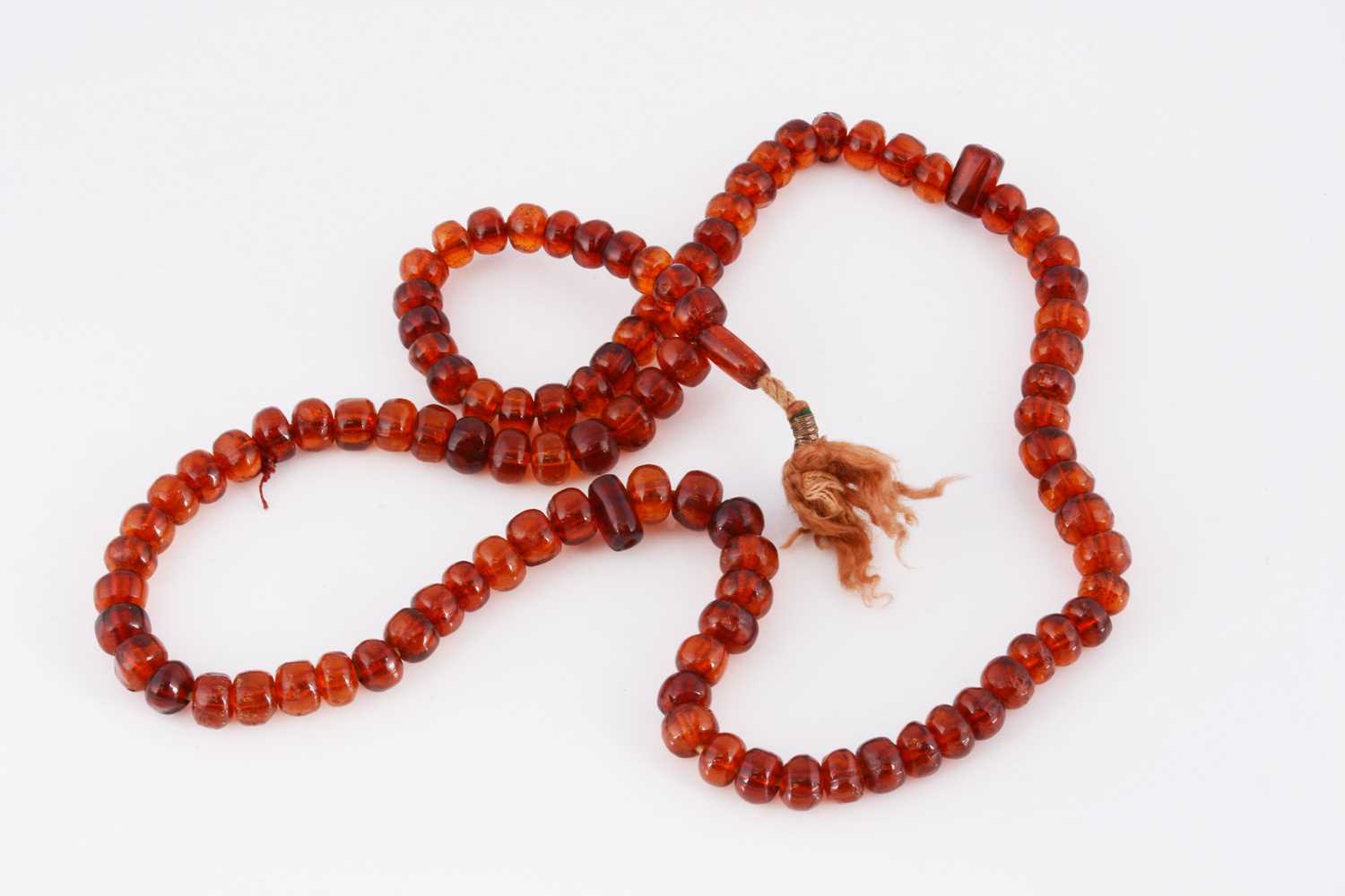 Lot 101 - A string of amber prayer beads