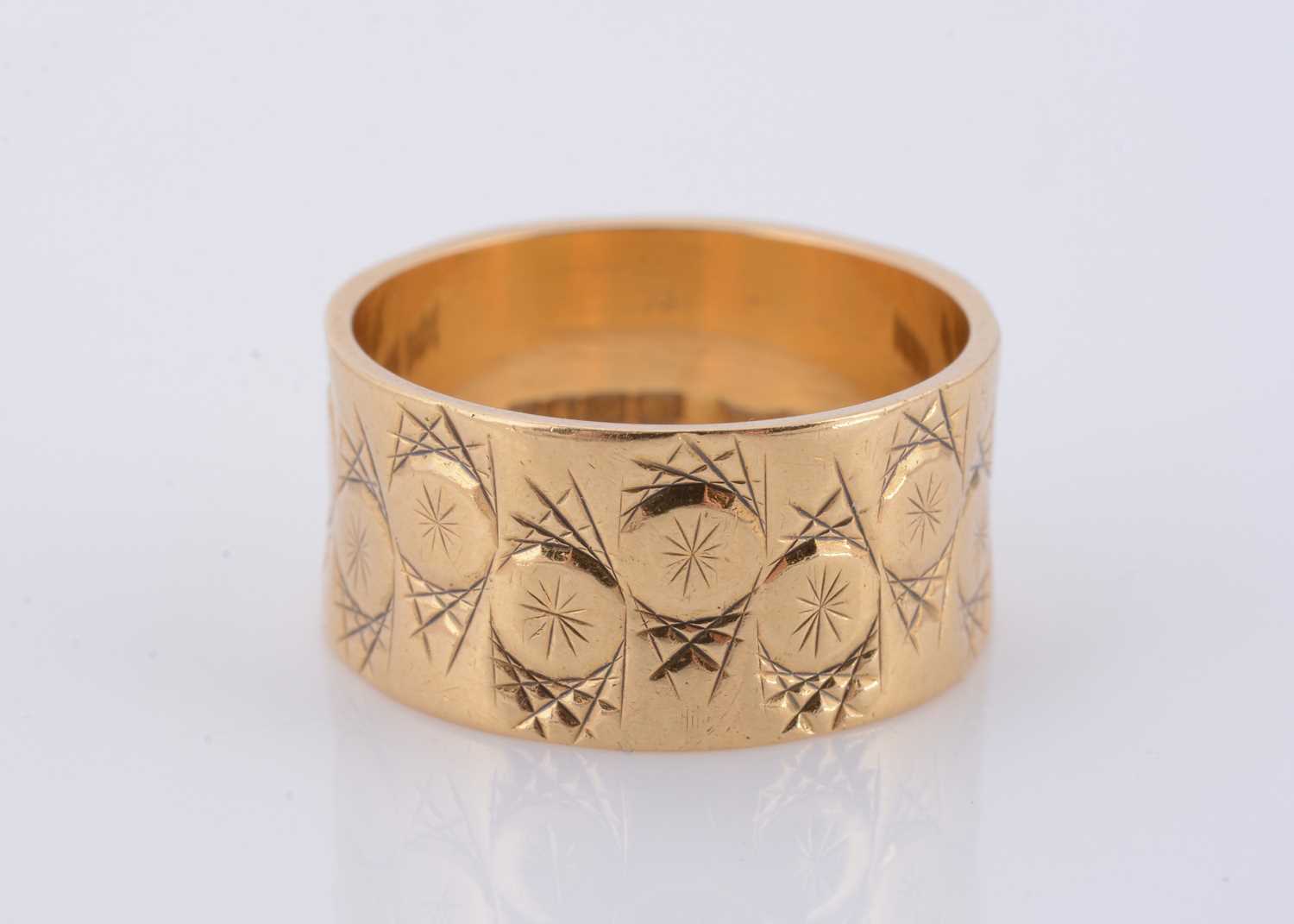 Lot 118 - An 18ct gold wide engraved wedding band