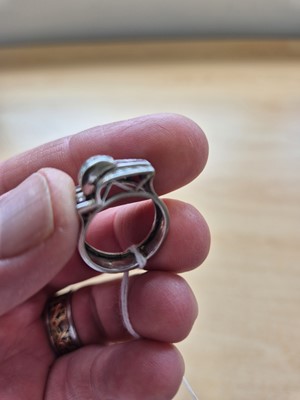 Lot 141 - An art deco ruby and diamond stylised buckle ring