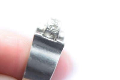 Lot 141 - An art deco ruby and diamond stylised buckle ring