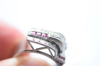 Lot 141 - An art deco ruby and diamond stylised buckle ring