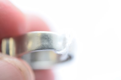 Lot 141 - An art deco ruby and diamond stylised buckle ring