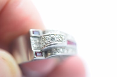 Lot 141 - An art deco ruby and diamond stylised buckle ring