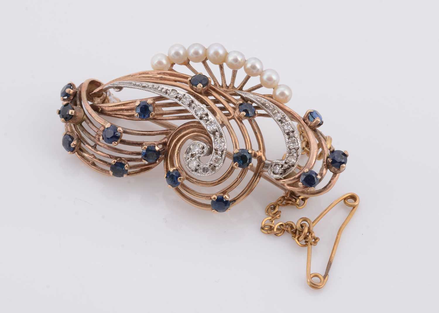 Lot 160 - A double scroll sapphire and diamond 9ct gold brooch