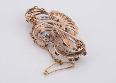 Lot 160 - A double scroll sapphire and diamond 9ct gold brooch