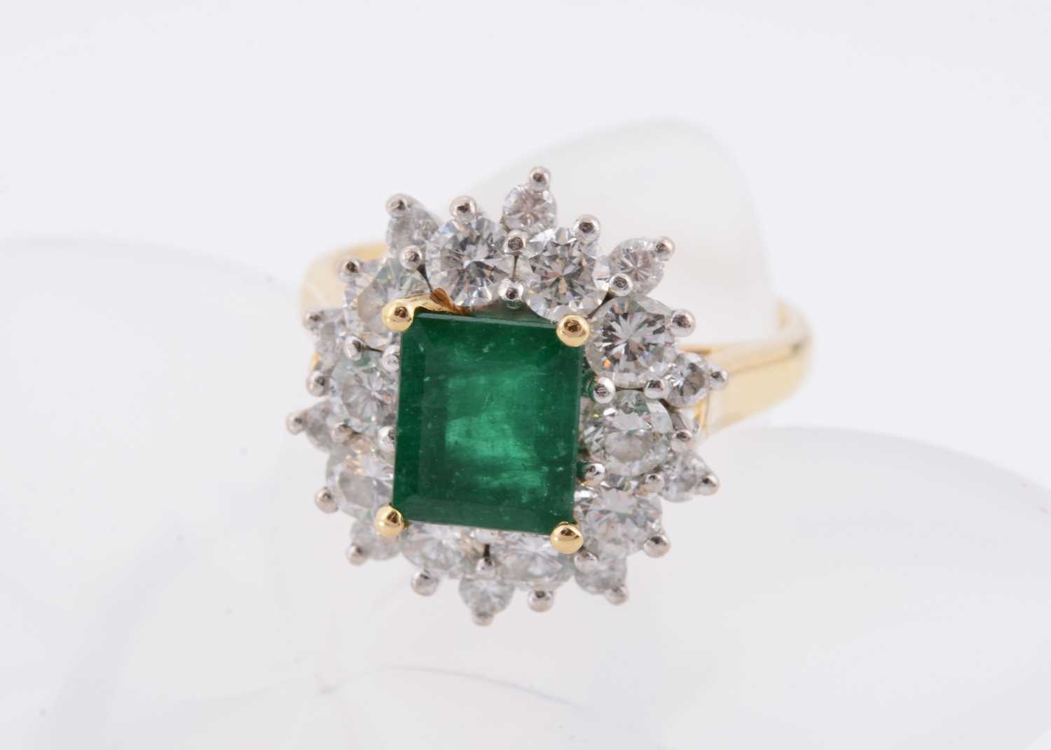 Lot 172 - An 18ct gold two colour emerald and diamond cluster ring