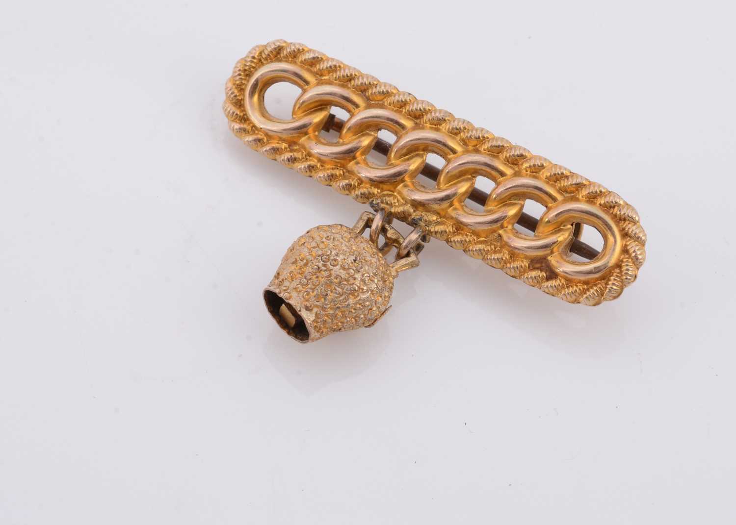 Lot 192 - A 9ct gold bar brooch and cow bell