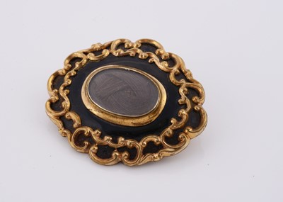 Lot 235 - A 19th Century oval gilt metal black enamel and plaited hair mourning brooch