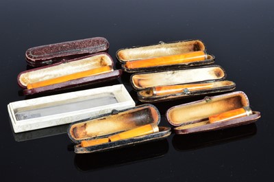 Lot 365 - A George V silver comb holder and three amber cheroot holders