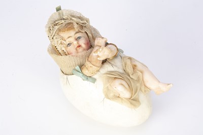 Lot 1194 - A rare German wax over composition baby in egg candy container circa 1900