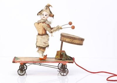 Lot 1280 - A late 19th century bisques headed drumming Punchinello pull along toy