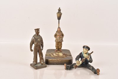 Lot 505 - A cold painted figure of a seated sailor holding a raffle