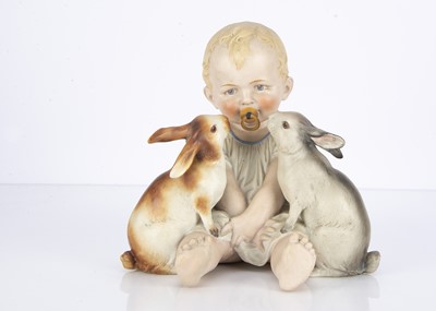 Lot 1368 - A Hertwig bisque piano baby with two rabbits