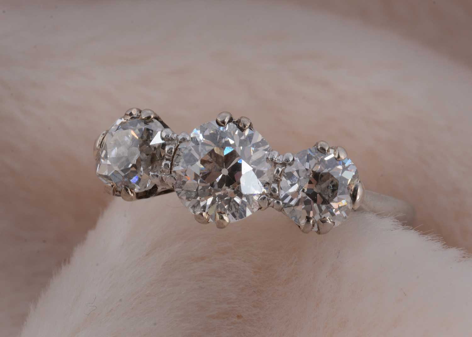Lot 31 - An art deco platinum three stone diamond dress ring