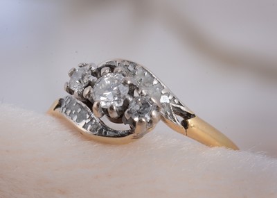 Lot 50 - An 18ct gold and platinum three stone crossover dress ring