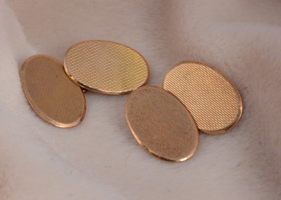 Lot 57 - A pair of 9ct gold engine turned oval cufflinks