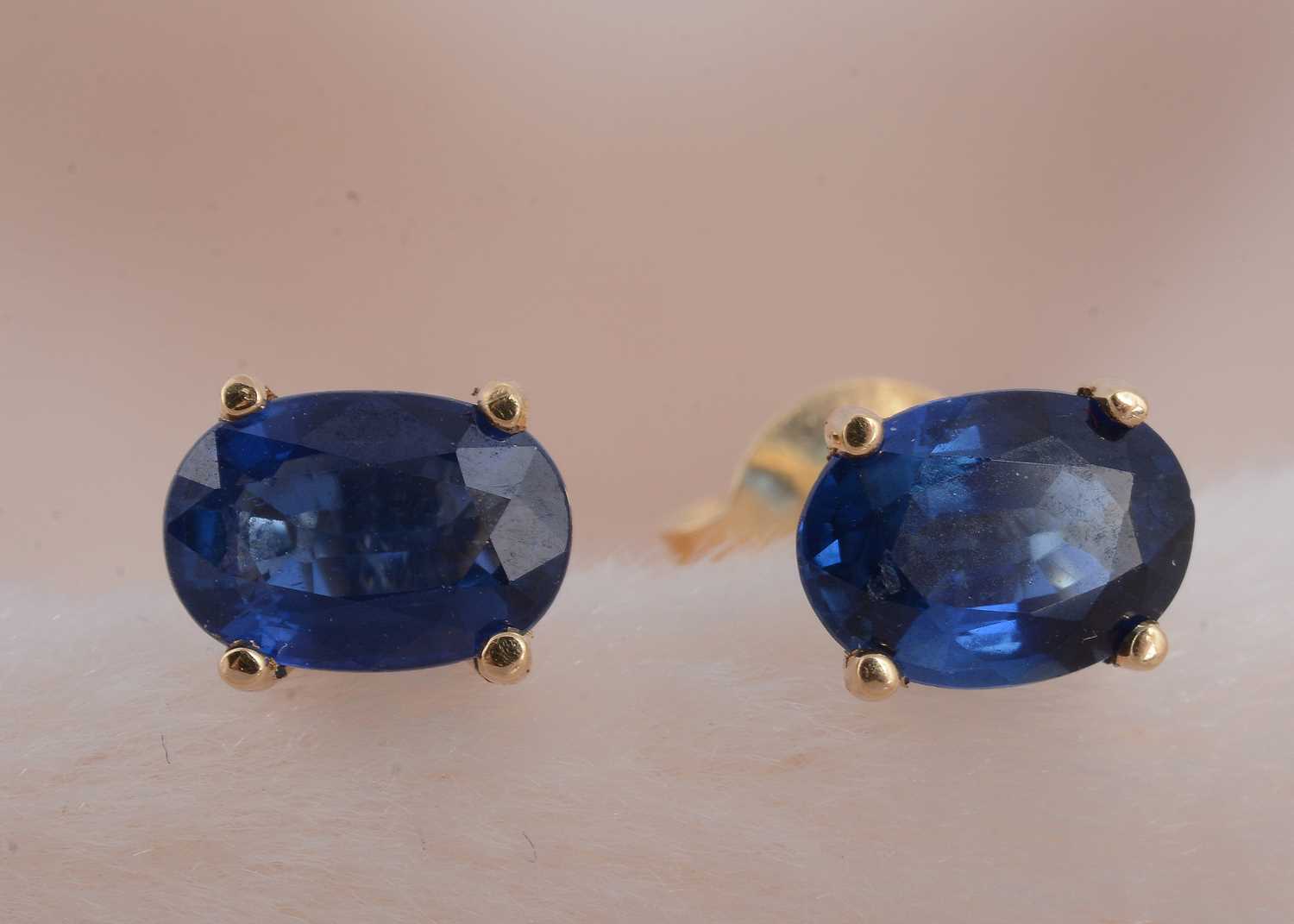 Lot 70 - A pair of 18ct gold oval mixed cut sapphire ear studs