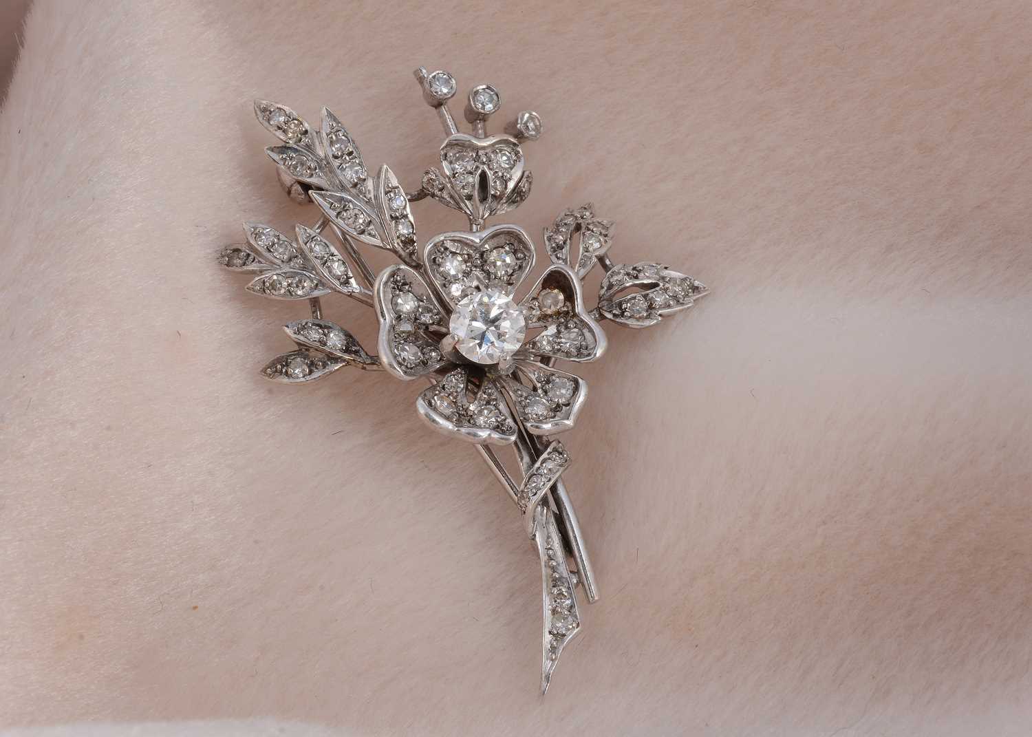 Lot 77 - A 9ct white gold floral diamond set spray brooch