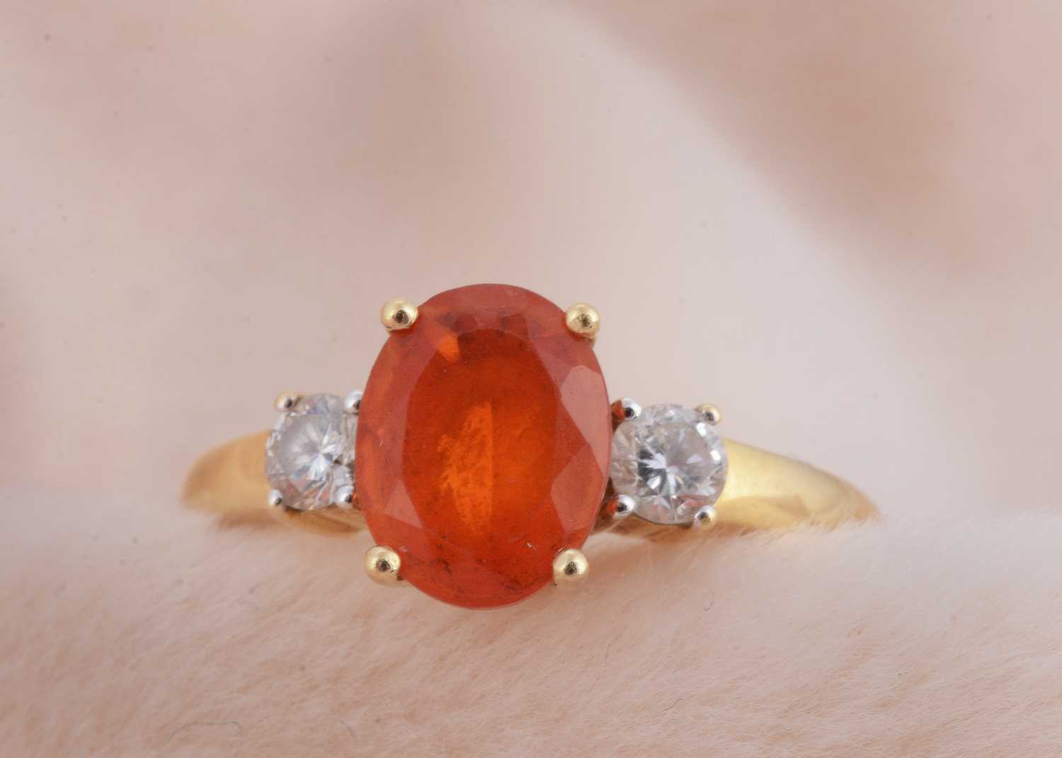 Lot 92 - An 18ct gold fire opal and diamond three stone dress ring
