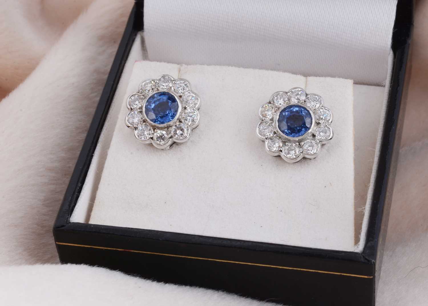 Lot 93 - A pair of 18ct white gold sapphire and diamond cluster ear studs